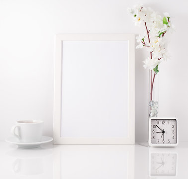 White frame, flower in vase, cup with tea or coffee, clock on wh