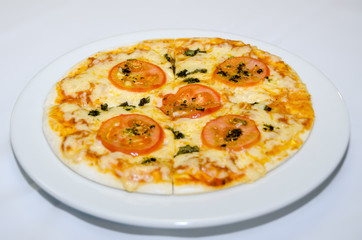 Pizza with melted cheese and tomato slices