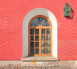 Brick House Wall with Arch Window and Outdoor Street Lantern. Old Vintage Classic House Facade with Vibrant Bright Red Brick Stone Wall Texture. Ornamental Simple Archway Window Architecture Detail. 