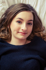 Naklejka premium Beautiful young girl relaxing in the bedroom.