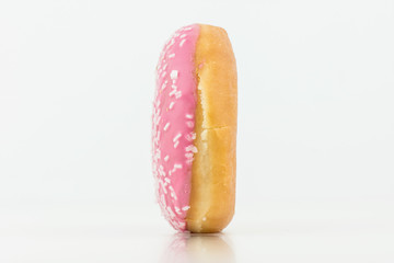 Closeup Of Delicious Pink Colored Donut On White Background With White Chocolate On It.Isolated