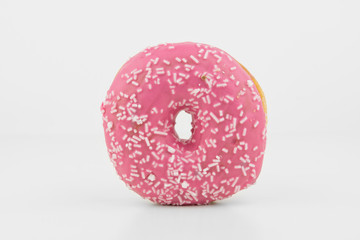 Closeup Of Delicious Pink Colored Donut On White Background With White Chocolate On It.Isolated