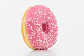 Closeup Of Delicious Pink Colored Donut On White Background With White Chocolate On It.Isolated