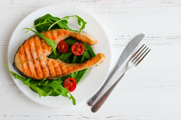 Grilled salmon steak with tomatoes cherry and spinach