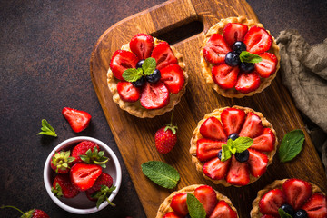 Strawberry tart on dark table.