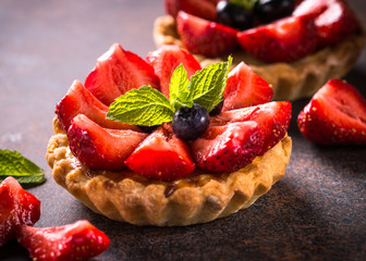 Strawberry tart on dark table.