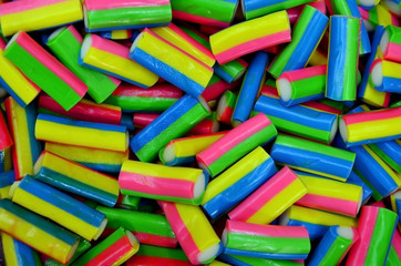  long rainbow shape bright sugar marmalade candy flavor fruit, colorful jelly dessert sweet close-up,  background.