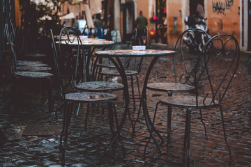 Outdoor cafe tables on a Trastevere street after rain