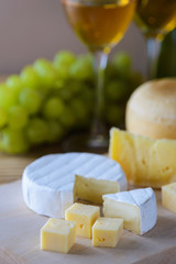 Different types of cheeses on a wooden board