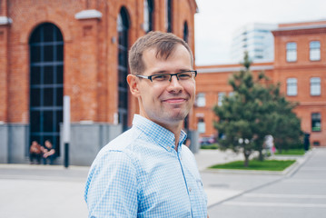 Fototapeta premium Portrait of attractive european guy in casual shirt and glasses