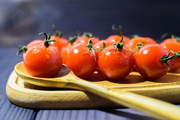 cherry tomatoes close-up on a dark background in a wooden dish