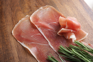 prosciutto jamon ham on a wooden background rosemary