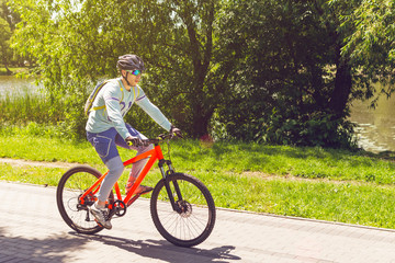 Naklejka premium A cyclist in a helmet rides a bicycle path