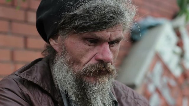 A portrait of an old homeless man