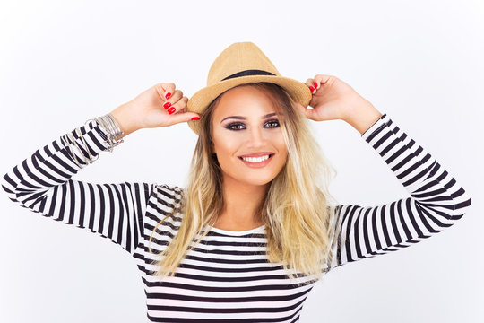 Closeup portrait of gorgeous blonde teenage girl with straw hat wearing black and white striped shirt