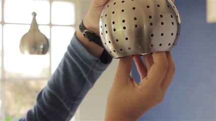Hand Changing a Ceiling Light Bulb. Close-Up. 