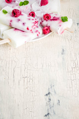 Summer sweet desserts, homemade organic ice cream popsicles from raspberry and yogurt, light beige background copy space