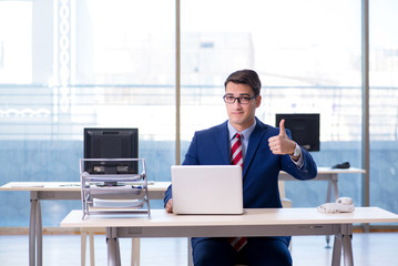 Young handsome businessman employee working in office at desk