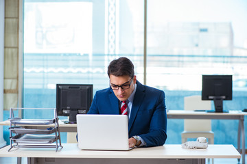 Young handsome businessman employee working in office at desk