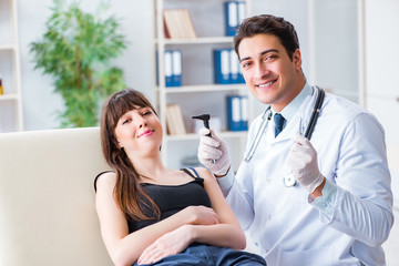 Doctor checking patients ear during medical examination