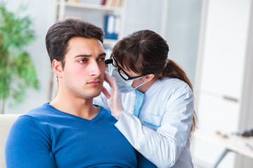 Doctor checking patients ear during medical examination