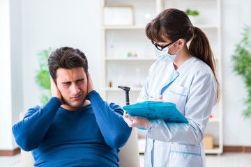 Doctor checking patients ear during medical examination