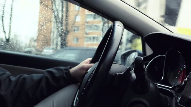 Man Hands On Steering Wheel Driving In Rainy Day