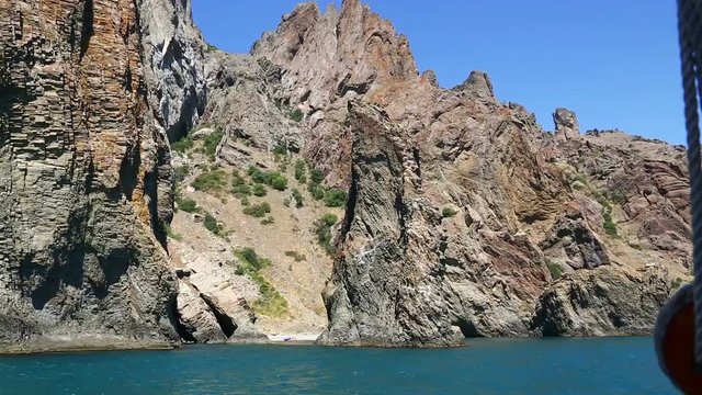 View from the ship to the rocky cliff. Camera moves from right to left