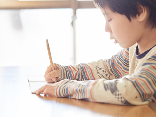自宅で算数の宿題をする小学生の男の子