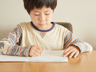 自宅で算数の宿題をする小学生の男の子