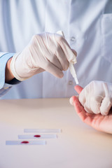 Doctor taking blood samples from finger