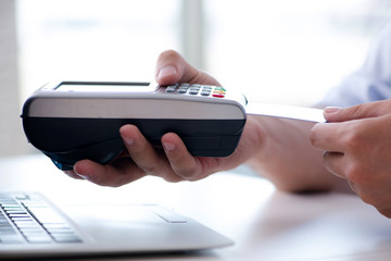 Man processing credit card transaction with POS terminal
