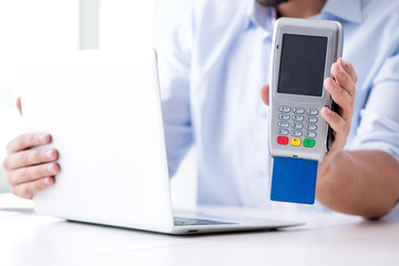 Man processing credit card transaction with POS terminal