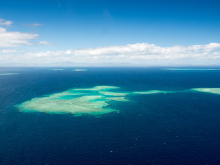 Aerial Landscape View of South Pacific Reef Island Surrounded by Deep Blue Ocean in Summer Weather