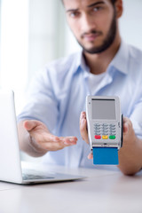 Man processing credit card transaction with POS terminal