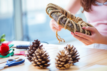 Woman making homemade cone wreath