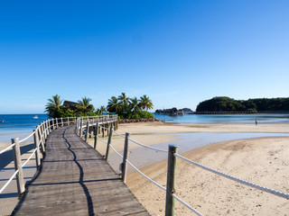 Ocean Landscape Boardwalk Walkway Over Beach out to Lone Palm Tree Island in Fiji