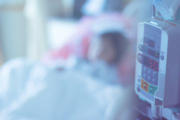 saline infusion Pump and Syringe Pump patient on bed  blur background .selective focus at saline infusion pump and syringe pump