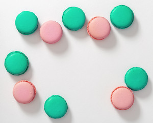 Groups of tasty macaroon biscuits of green and pink color on a white background. Colorful macaroons cake. Copy space. Selective focus. Top view.