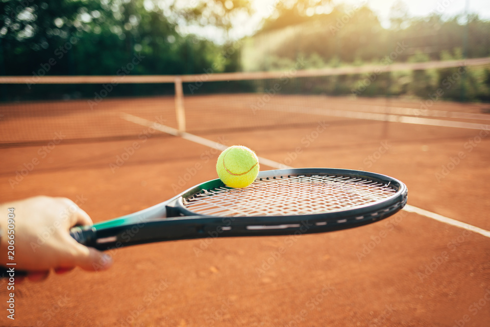 Wall mural Tennis player hand holding racket and ball 