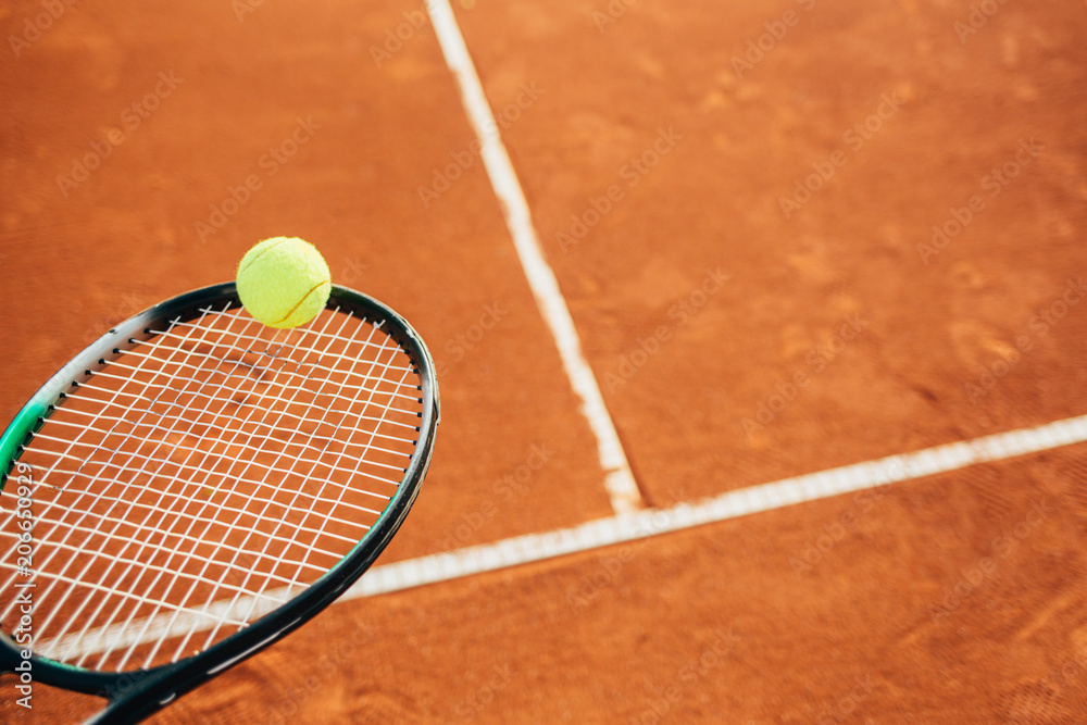 Wall mural Close up of tennis racket and ball on clay court