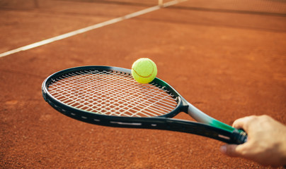Tennis racket and ball on the clay court