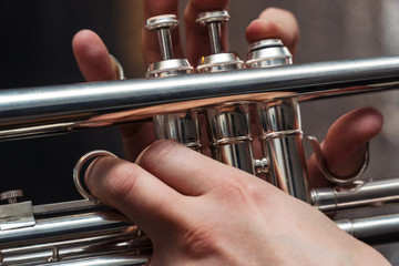 Obraz premium Hand of the Trumpeter on the buttons of trumpet