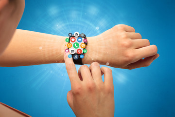 Hand with smartwatch and application symbols nearby.
