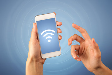 Female fingers touching smartphone with wireless connection icon