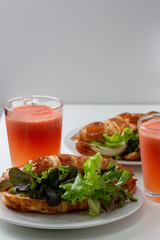 croissant with salad, cheese and tomatoes on wooden background.