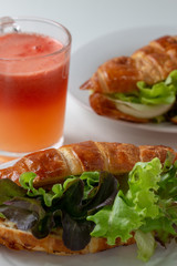 croissant with salad, cheese and tomatoes on wooden background.