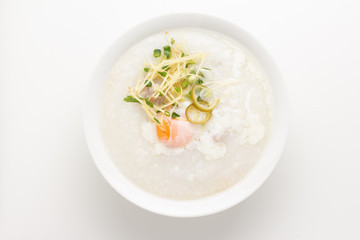 Asian congee with minced pork and egg in white bowl.