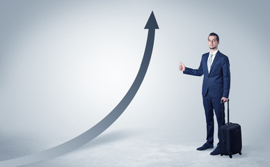 Young businessman hitchhiking with progressive arrow concept and copyspace
