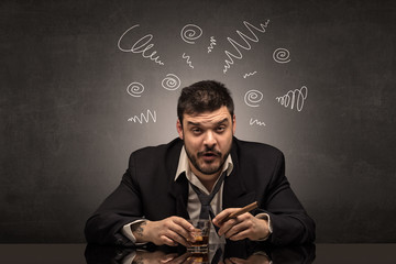 Young drunk man at his office with doodles around
